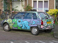 828714 Afbeelding van een auto, geparkeerd voor de huizen Vijgeboomstraat 7-9 te Utrecht, volgeplakt met stickers en ...